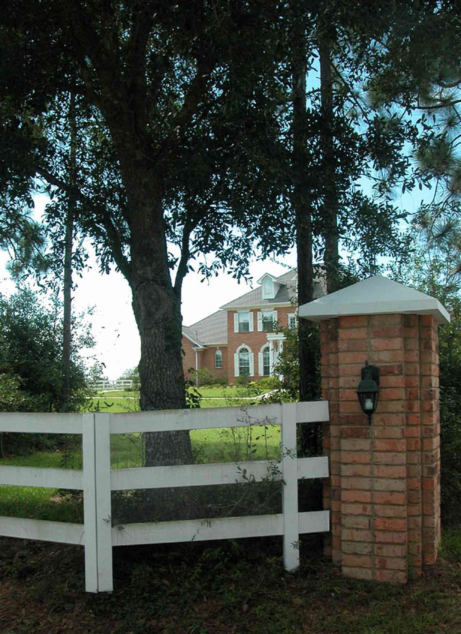Cantonment:-Milestone:-Red-Brick-Mansion-A_00.jpg:  white fence, board fence, brick pillar, gate entrance, red brick house, circular driveway