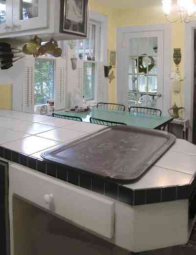 East-Pensacola-Heights:-600-Bayou-Blvd_16.jpg:  kitchen, white ceramic tile, dining area, french door, wood shutters