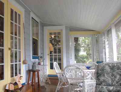 East-Pensacola-Heights:-600-Bayou-Blvd_24.jpg:  screened porch, wicker furniture, wooden floors, french doors
