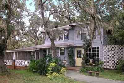 East-Pensacola-Heights:-600-Bayou-Blvd_26.jpg:  wood frame construction, mossy oaks, spanish moss, side door, screen porch, brick pillars, bayou view, camellia bush, 