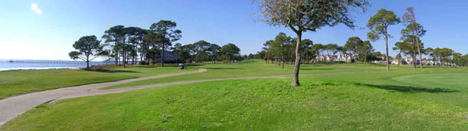 Gulf-Breeze:-Tiger-Point-Golf-Club_09.jpg:  golf course, green, pine trees, santa rosa sound, golfer, caddie