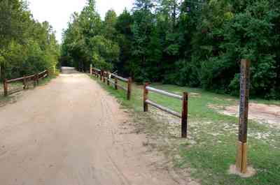 Milton:-Adventures-Unlimited_08.jpg:  dirt road, wooden fence, forest, park, camp, swamp