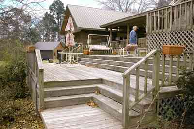 Milton:-Floyd-Farm_06.jpg:  porch, deck, fireplace, log cabin, hills, valley, pond, oak trees, sofa, chaise lounge, umbrella table, lake