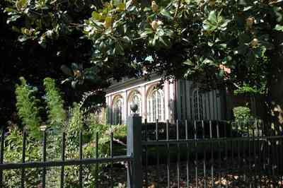 North-Hill:-105-West-Gonzales-Street_04.jpg:  wrought-iron fence, leaded glass windows, magnolia tree, french colonial architecture
