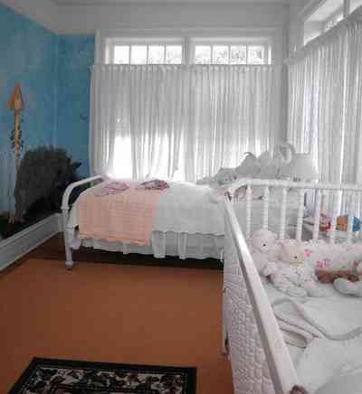 North-Hill:-105-West-Gonzales-Street_65.jpg:  baby crib, stuffed animals, white eyelet curtains, quilt, wall mural