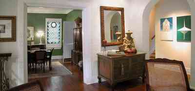 North-Hill:-123-West-Lloyd-Street_10.jpg:  living room, arched doorway, oriental rug, stained glass window, wicker chair