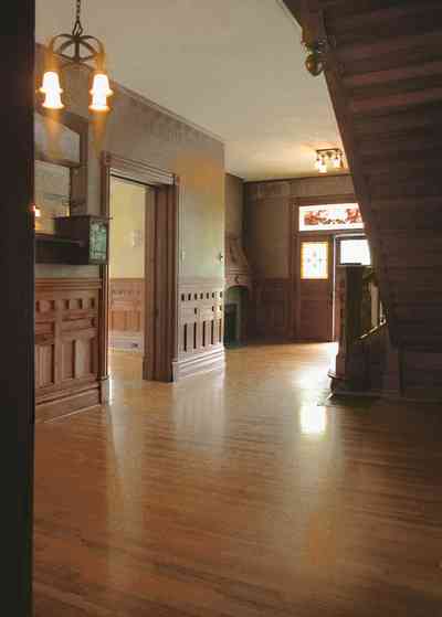 North-Hill:-304-West-Gadsden-Street_14.jpg:  faux walls, stenciled borders, central hall, staircase, oak wainscotting, chandelier, stained glass transom, front door