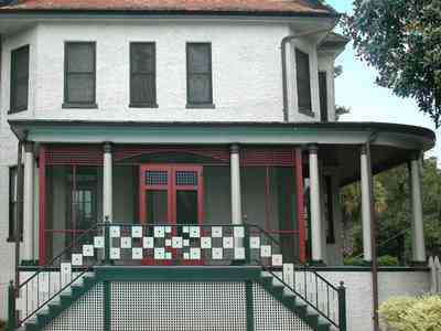 North-Hill:-304-West-Gadsden-Street_26.jpg:  side porch, column, stairs, stucco house, magnolia tree, lattice work