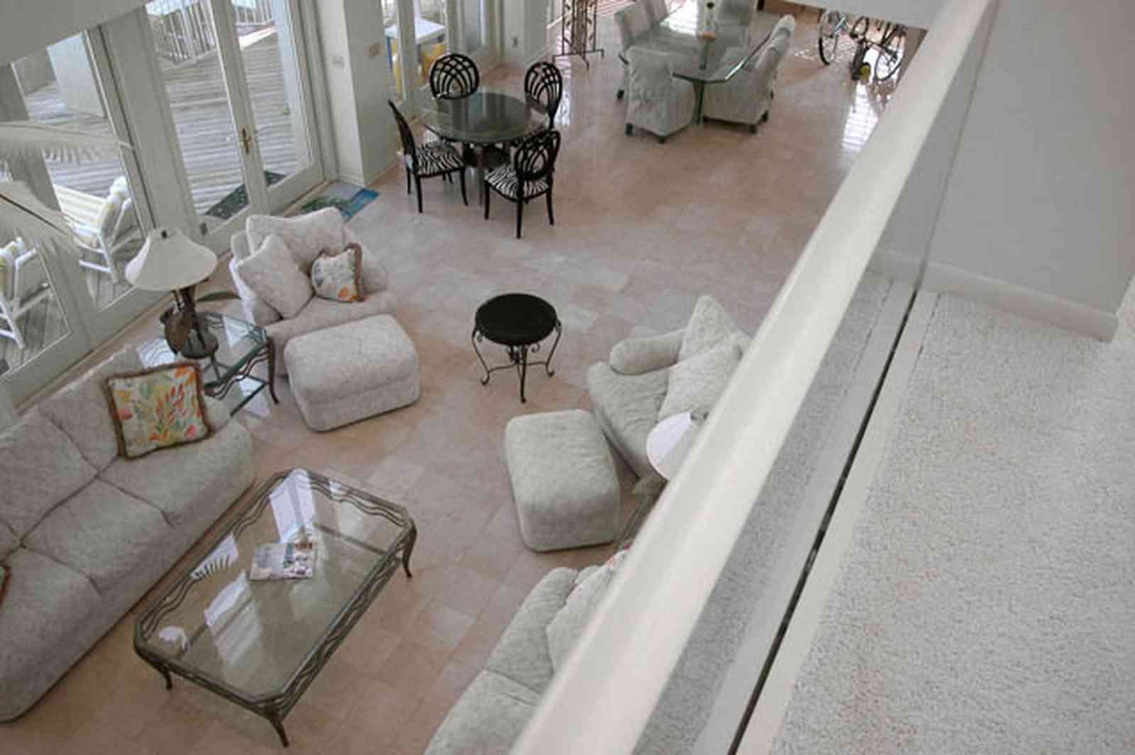 Pensacola-Beach:-1212-Ariola-Drive_05.jpg:  glass balcony, glass coffee table, travitine marble, white carpet, sofa, 