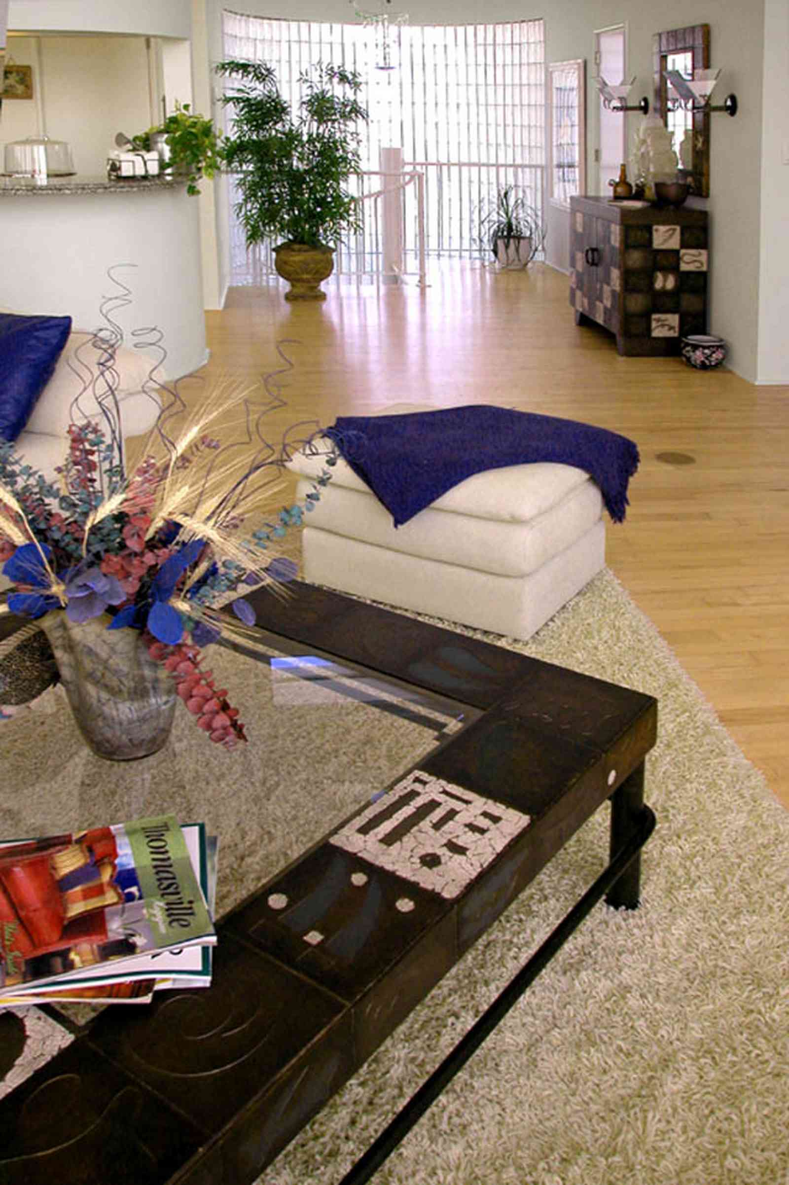 Pensacola-Beach:-Ariola-Drive-Art-Deco-House_30b.jpg:  beach front home, gulf of mexico, coffee table, foot stool, hassock, leather sofa, area rug, wood floors, spiral staircase, flower arrangement