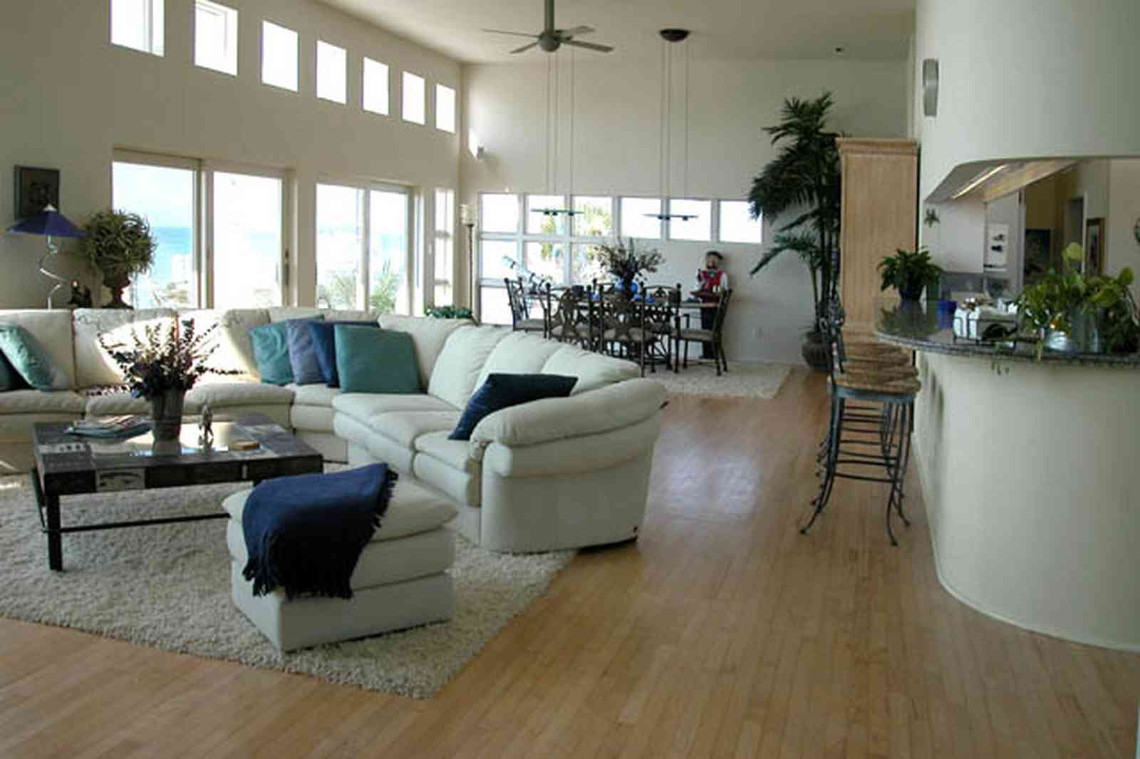Pensacola-Beach:-Ariola-Drive-Art-Deco-House_31.jpg:  sectional sofa, leather sofa, hassock, beachfront home, coffee table, bar stools, grantite countertop, ceiling fan, patio doors, dining room table, beach