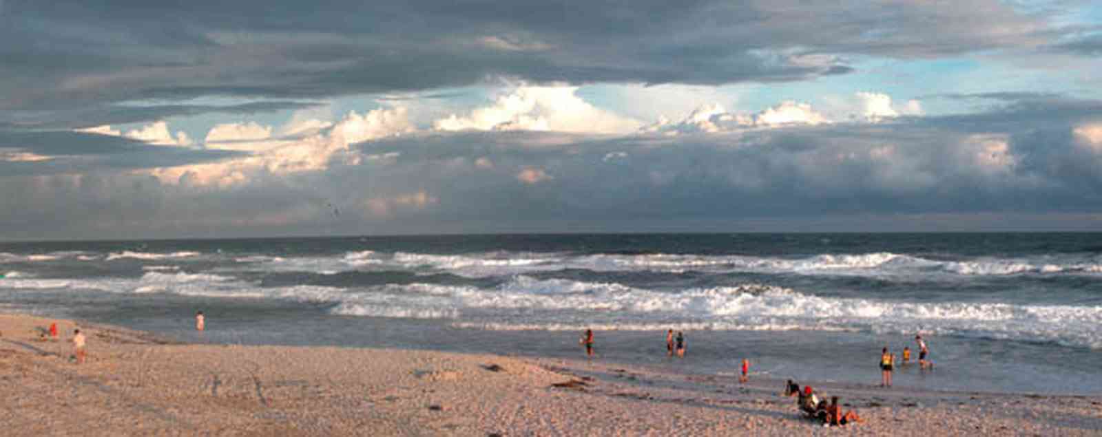 Pensacola-Beach:-Casino-Beach_01b.jpg:  surf, waves, beach front, cumulus clouds, storm surge, bathers, swimmers, gulf of mexico, tropical storm, mixed skies, 