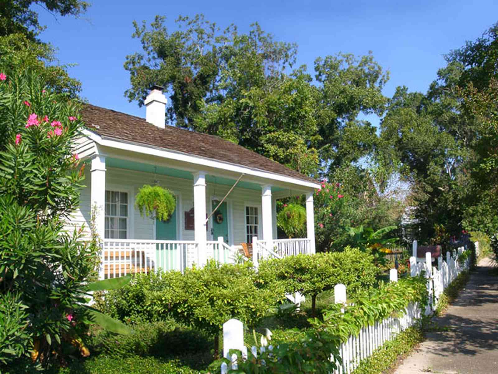 Pensacola:-Seville-Historic-District:-211-South-Florida-Blanca-Street_05.jpg:  creole cottage, picket fence, wood shingle roof, fern, oleander bush