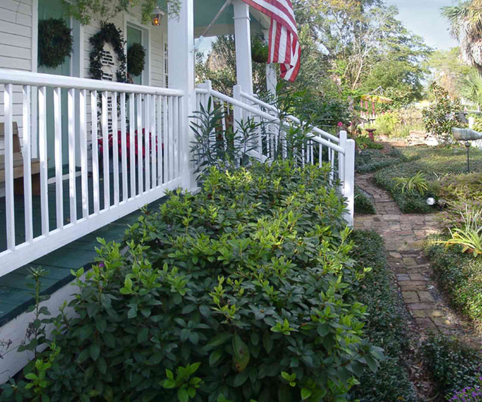 Pensacola:-Seville-Historic-District:-211-South-Florida-Blanca-Street_08.jpg:  american flag, porch, brick path, gulf coast cottage