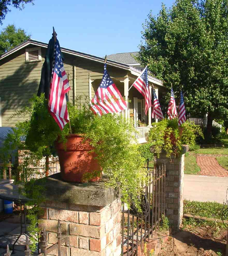 Pensacola:-Seville-Historic-District:-215-Cevallos-Street_.jpg:  american flag, wrought iron fence, creole cottage