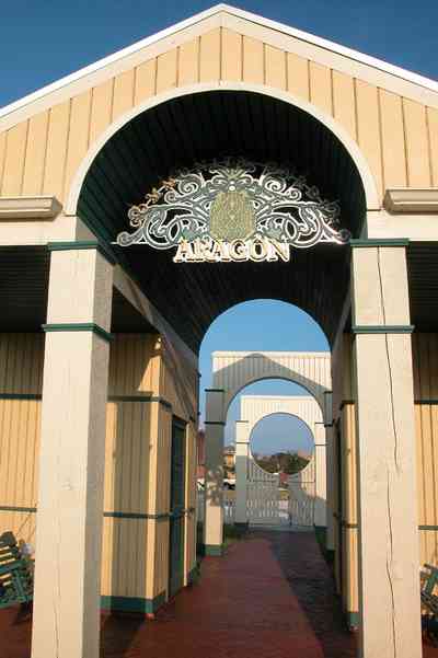 Aragon:-Childrens-Playground_03.jpg:  arch, columns, playground, picket fence, gateway, gate, porch swing