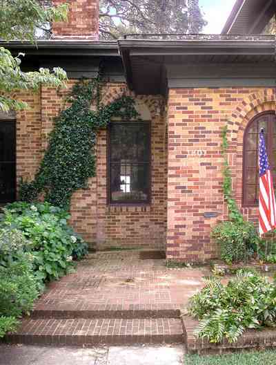 East-Hill:-1801-East-La-Rua-Street_02.jpg:  brick house, front steps, american flag, ivy covered wwall, hydranga bush, brick step