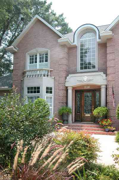 East-Hill:-617-19th-Avenue_04.jpg:  etched glass door, pediment, columns, ferns, american flag, pink brick house, 