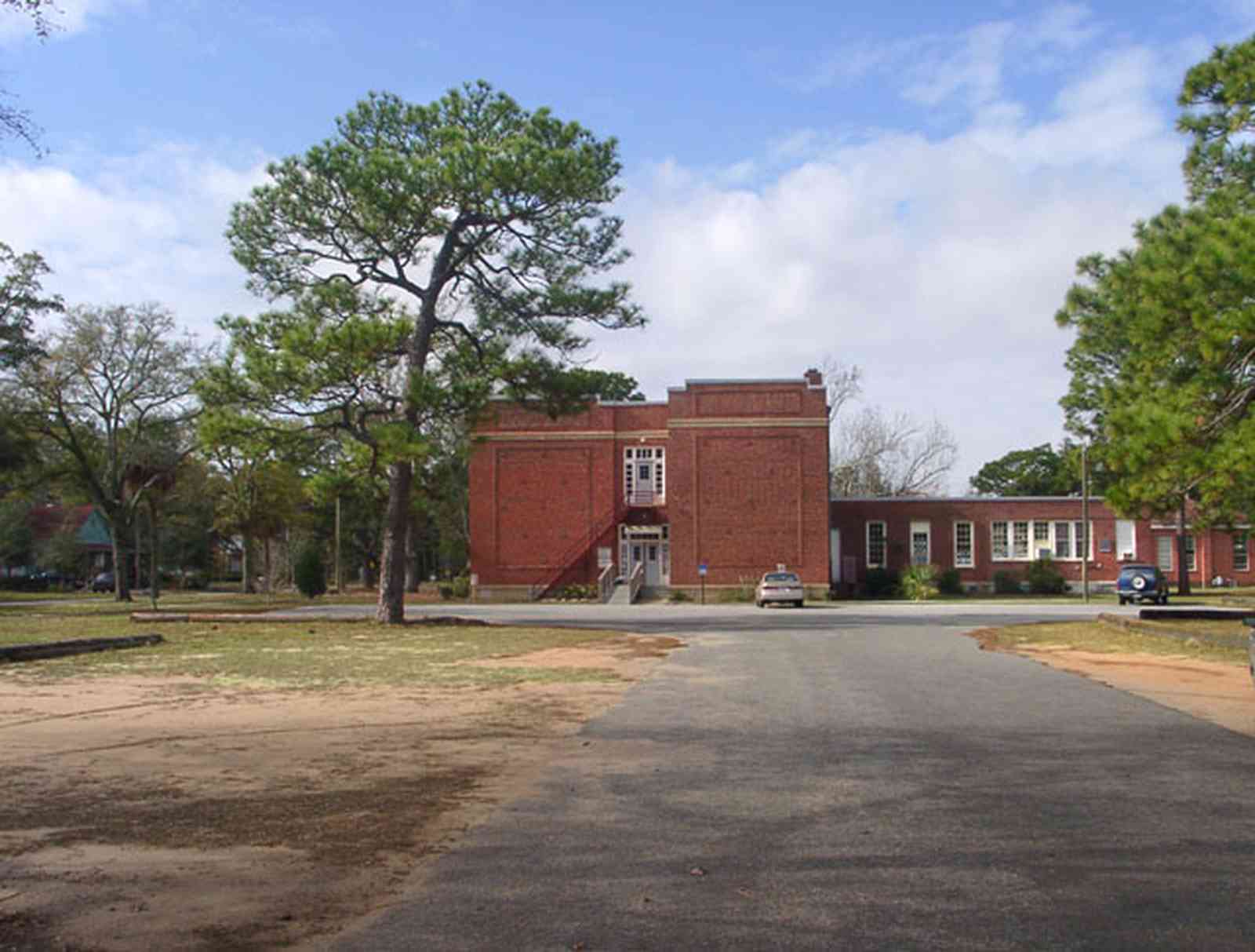 East-Hill:-Agnes-MacReynolds-School_04.jpg:  brick school house, parking lot, pine trees