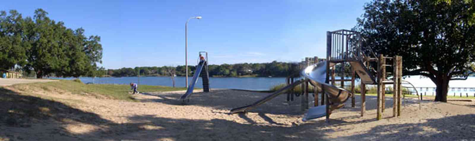 East-Hill:-Bayview-Park_03a.jpg:  slide, swing, playground equipment, bayou texar, magnolia tree, sand lot, play area