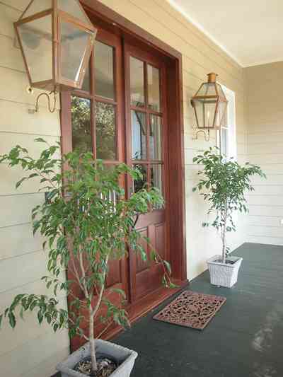 East-Pensacola-Heights:-112-Chipley-Avenue_04.jpg:  mahogany doors, gas lanterns, raised cottage