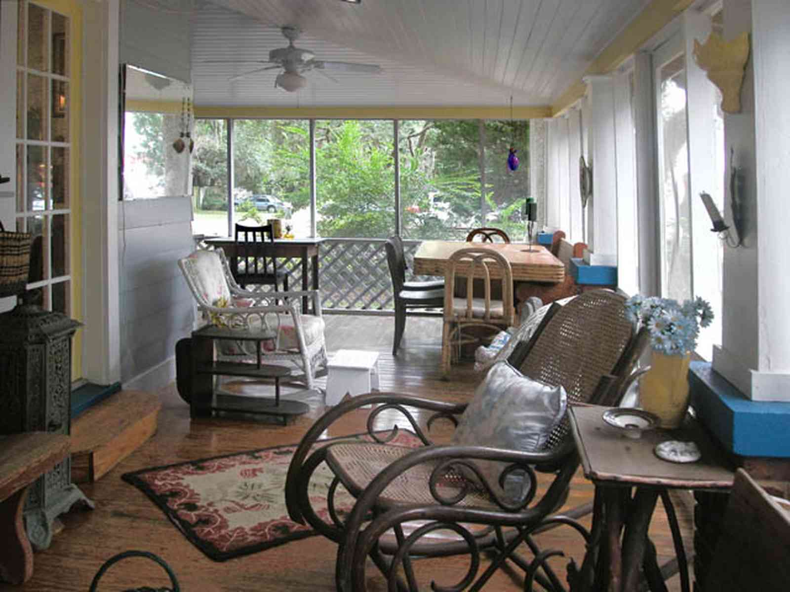 East-Pensacola-Heights:-600-Bayou-Blvd_04.jpg:  front porch, wicker furniture, ceiling fan, oriental rug, french door
