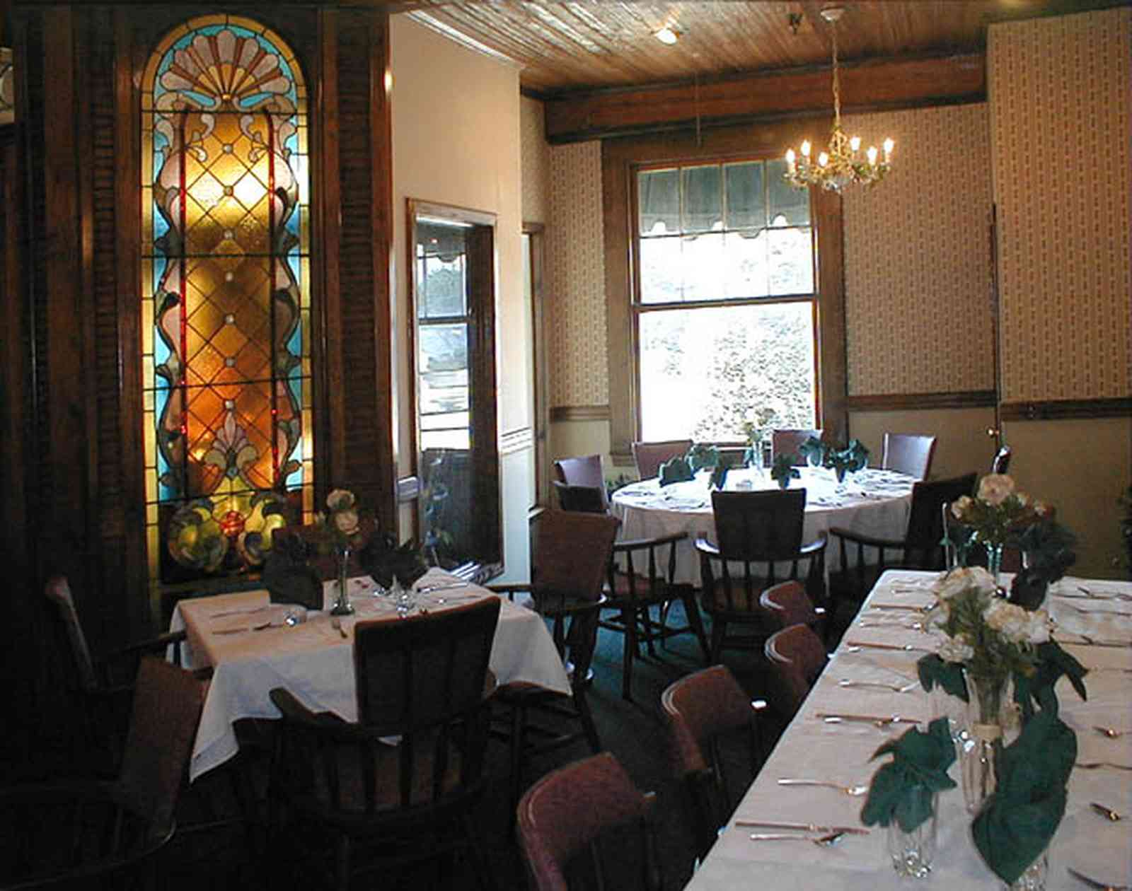 Foley:-The-Gift-Horse-Restaurant_02.jpg:  brass chandelier, beaded pine walls, buffet table, banquet table, silver compote, stained glass windows, table linen, restaurant