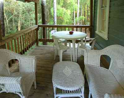 Milton:-Adventures-Unlimited_29.jpg:  wicker furniture, back porch, creek