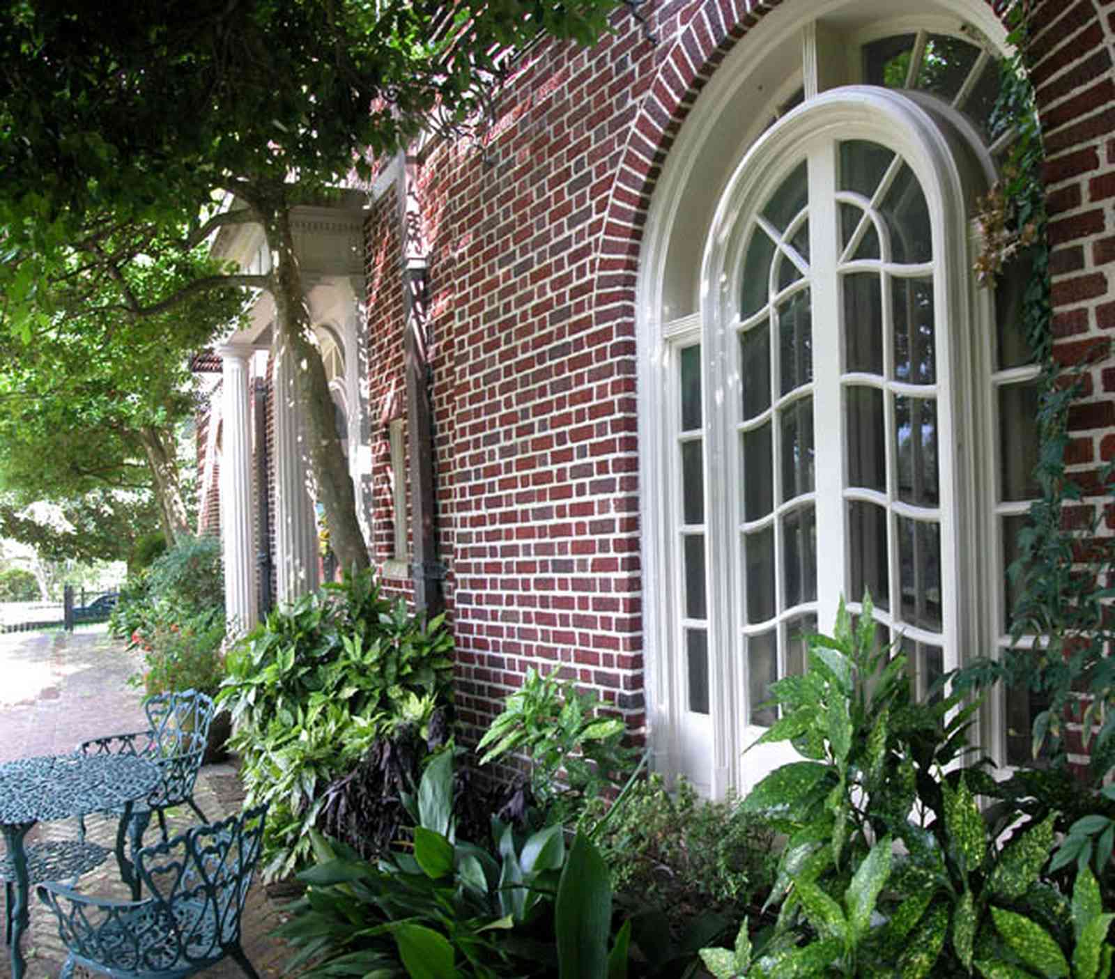North-Hill:-105-West-Gonzales-Street_02a.jpg:  porch, balcony, oak tree, brick terrace, french colonial architecture, wrought-iron fence