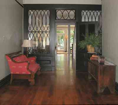 North-Hill:-116-DeSoto-St_02c.jpg:  heartpine floors, entry hall, red sofa, potted fern, central hall