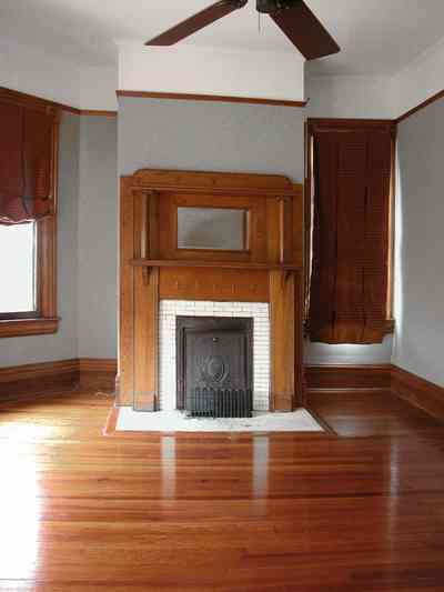 North-Hill:-304-West-Gadsden-Street_27.jpg:  fireplace, wooden mantel, heart pine floors, swag curtains, ceiling fan