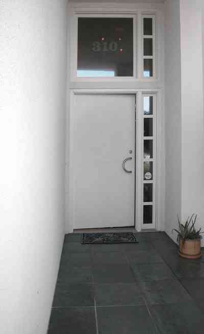 Pensacola-Beach:-Ariola-Drive-Art-Deco-House_17.jpg:  sand, crystal sand, white sand, sugar sand, sea oats, bauhaus architectural style, palm trees, dune restoration, stairs, glass railing, wooden deck, front door, glass blocks,  beachfront property