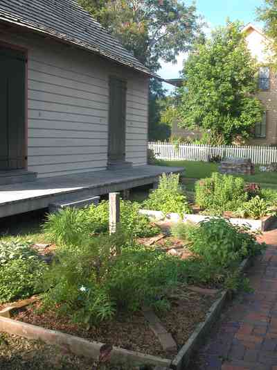 Pensacola:-Historic-Pensacola-Village:-LaValle-House_2c.jpg:  picket fence, wood shingle roof, kitchen garden, spices, herbs, brick sidewalk, basil, oregano, thyme
