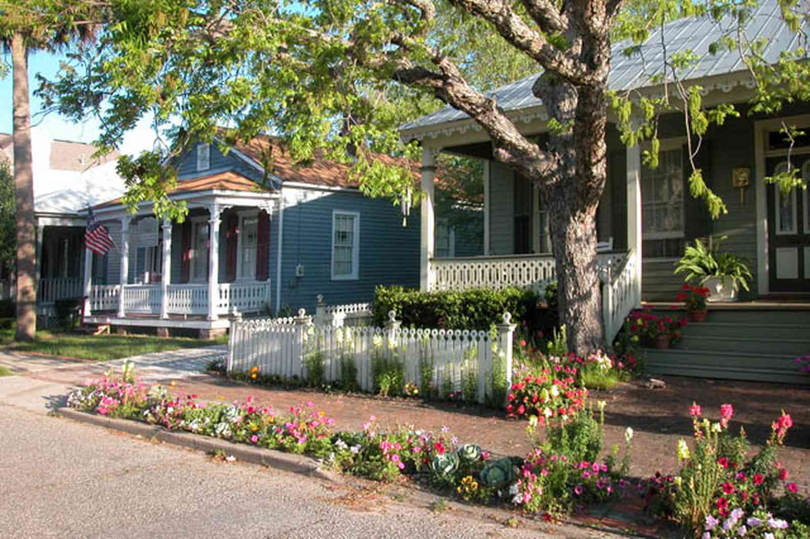 Pensacola:-Seville-Historic-District:-226-East-Intendencia-Street_02.jpg:  snapdragons, cabbages, ferns, pecan tree, strawberry plants, peturnias, white picket fence, victorian front porch, pyramid roof, four-square georgian architectural style, victorian cottage, historic preservation, historic district, brick sidewalk, 