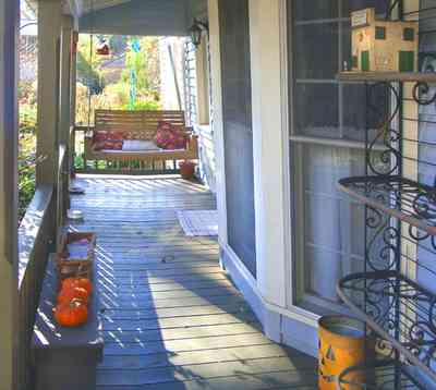 Pensacola:-Seville-Historic-District:-227-East-Intendencia-Street_03.jpg:  halloween pumpkin, wrought-iron shelves, porch swing, porch, bay window