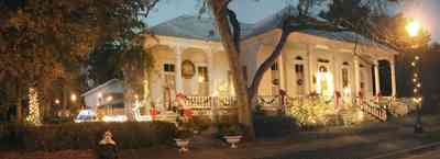 Pensacola:-Seville-Historic-District:-434-East-Zaragoza-Street_04.jpg:  christmas decoration, garland, festive, oak tree, front porch, four-square georgian architecture, wreath, fountain, pyramid roof, tin roof, gingerbread trim, street light,, underground power, brick sidewalk