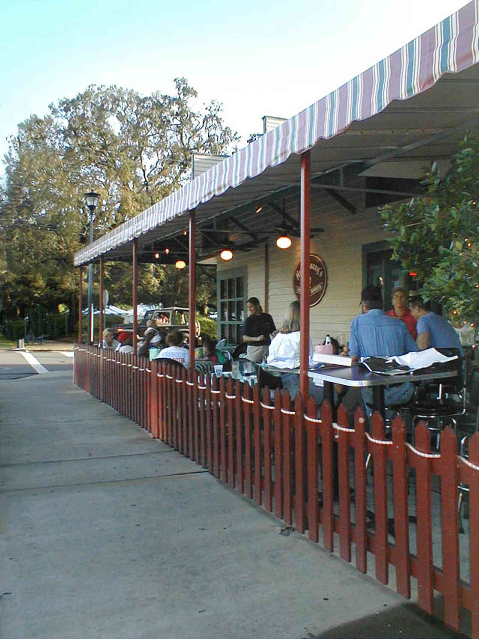 Pensacola:-Seville-Historic-District:-Hub-Staceys-Pub_10.jpg:  dining, restaurant, umbrella table, wisteria vine, hanging basket, sidewalk cafe, oak trees, pub, cocktails, beer, wine