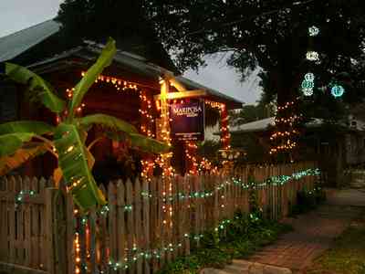 Pensacola:-Seville-Historic-District:-Mariposa-Gallery_04.jpg:  picket fence, oak tree, christmas decorating, brick sidewalk, banana tree