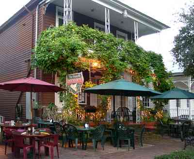 Pensacola:-Seville-Historic-District:-Tre-Fratelli-Italian-Restaurant_03.jpg:  umbrellas, sidewalk cafe, victorian home, wrought-iron railings