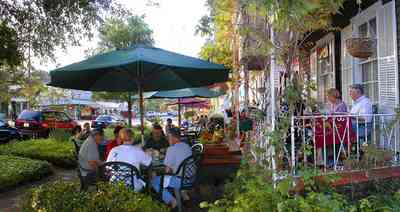 Pensacola:-Seville-Historic-District:-Tre-Fratelli-Italian-Restaurant_12.jpg:  dining, restaurant, umbrella table, wisteria vine, hanging basket, sidewalk cafe, oak trees