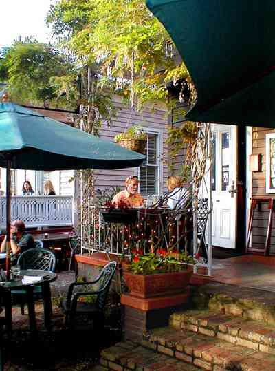 Pensacola:-Seville-Historic-District:-Tre-Fratelli-Italian-Restaurant_13.jpg:  dining, restaurant, umbrella table, wisteria vine, hanging basket, sidewalk cafe, oak trees
