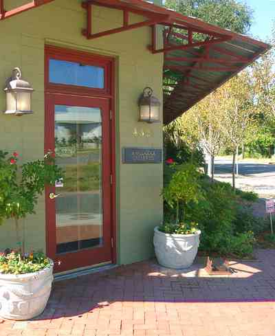 Pensacola:-Seville-Historic-District:-Woodcock-Galleries_02a.jpg:  rose bush, brick sidewalk, antique shop