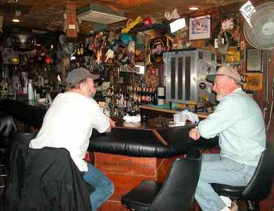 Perdido-Key:-Flora-Bama-Lounge_04.jpg:  bar patrons, waitress, bartender, bottles, fam, bar stools, song writers